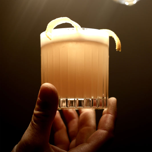 Der Whisky Sour gemixt mit einem Schuss Krink Liqueurs Bitter Aperitif. Gewinnt geschmacklich wie auch geruchlich durch die fruchtigen Orangennoten an Komplexität.