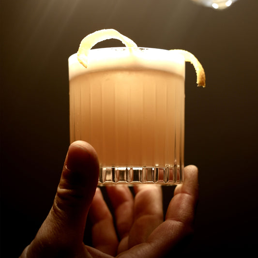Der Whisky Sour gemixt mit einem Schuss Krink Liqueurs Bitter Aperitif. Gewinnt geschmacklich wie auch geruchlich durch die fruchtigen Orangennoten an Komplexität. 